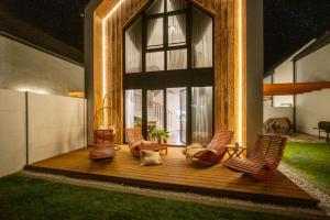 a deck with chairs and a large window at Olivina Park Spa - domki z dostępem do krytego basenu, saun, wyżywienia i atrakcji dla dzieci in Niechorze