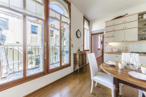 a kitchen and dining room with a table and chairs and windows at Citadelle in Venice