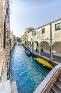 a canal in a city with two boats in the water at Citadelle in Venice