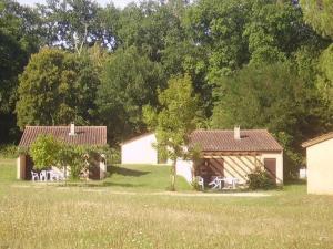 a group of houses with chairs in a field at Camping 3 étoiles - Piscine - ccbgbeh in Puy-lʼÉvêque