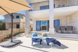 a patio with two chairs and an umbrella at Beach Residence MSJ in Sevid