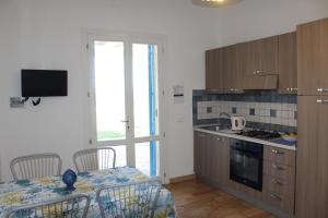 a kitchen with a table and chairs and a dining room at Baia dei Fenici in Birgi Vecchi