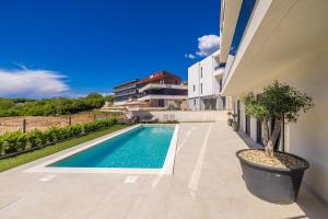 a swimming pool in the side of a house at Luxury apartment LaRiv II with pool in Krk +26 photos