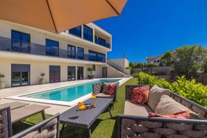 a backyard with a swimming pool and a villa at Luxury apartment LaRiv II with pool in Krk