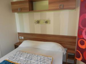 a small room with a bed and a mirror at Camping 3 étoiles - Piscine - ccbgaig in Loubeyrat