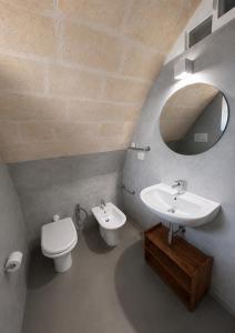 a bathroom with a sink and a toilet and a mirror at Il Giramondo Suite&Room in Matera