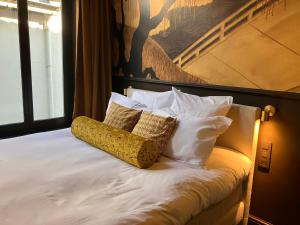 a bed with two pillows on top of it at Gilded Ox Suites in Deventer