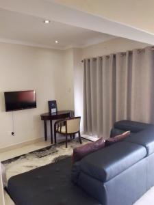a living room with a blue couch and a table at Hillview inn hotel in Serowe
