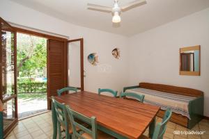 ein Esszimmer mit Tisch und Stühlen und einem Bett in der Unterkunft Villaggio Cala Verde in Copanello