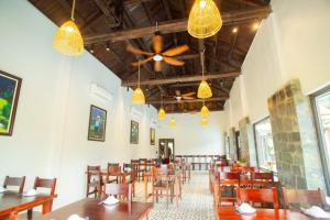a dining room with tables and chairs and a ceiling fan at Laco Green Trang An in Yên Ha