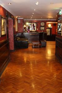 a lobby with a wooden floor and a bar at Hearns Hotel in Clonmel