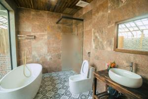 a bathroom with a tub and a sink and a toilet at Laco Green Trang An in Yên Ha +34 photos