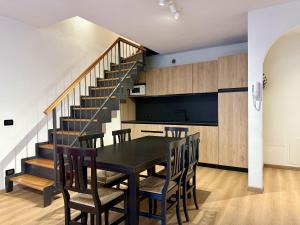 a dining room with a table and chairs and a staircase at Civetta Ski & Lake in Alleghe