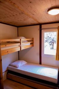 a bedroom with two bunk beds and a window at Chalet 2 étoiles - Piscine - ccbgdfh in Porto-Vecchio +6 photos