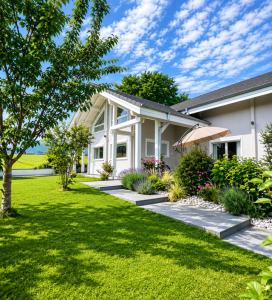 a house with a green lawn in front of it at Modern chalet next to Geneva in Divonne-les-Bains