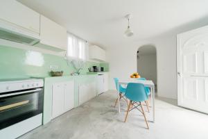 a kitchen with a table and a blue chair at Almond Deluxe Suite in Santorini