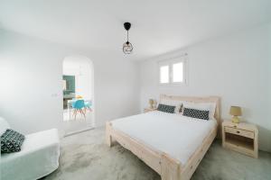 a white bedroom with a bed and a table at Almond Deluxe Suite in Santorini