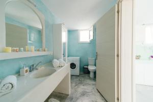 a bathroom with a sink and a toilet at Almond Deluxe Suite in Santorini +10 photos