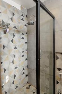 a bathroom with a shower with a glass door at The Twelve Petals by Parvati Inn in Dhikuli +47 photos
