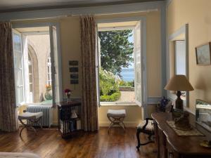 a living room with a large window with a view at Manoir Mer & Pins in Fouesnant +32 photos