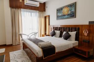 a bedroom with a large bed and a window at The Twelve Petals by Parvati Inn in Dhikuli
