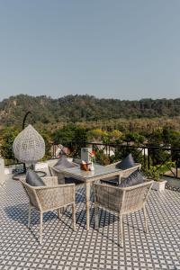 a table and chairs on a patio with a view at The Twelve Petals by Parvati Inn in Dhikuli