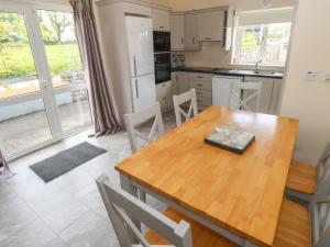 a kitchen and dining room with a wooden table and chairs at River House in Ballina