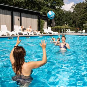a group of people playing volleyball in a swimming pool at Park Berkenrhode in Wekerom
