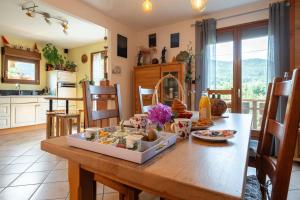 a kitchen and dining room with a table with food on it at Chambre d'hôtes Basinroche in Saulxures-sur-Moselotte
