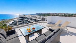 a balcony with a table and chairs and the ocean at Infinity View Penthouses by NRAS in Arenales del Sol