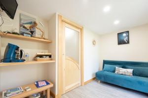 a living room with a blue couch and a mirror at Chambre d'hôtes Basinroche in Saulxures-sur-Moselotte
