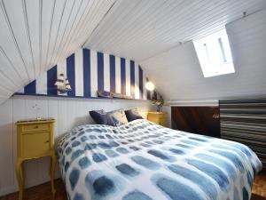 a bedroom with a bed with a blue and white comforter at Brittany Escape with Garden in Kersaudy