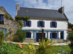 a white and blue house with blue shutters at Brittany Escape with Garden in Kersaudy