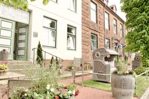 a garden with flowers in front of a building at Lexow - Hotel an de Havenkant in Tönning +21 photos