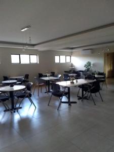 a large room with tables and chairs and windows at Hillview inn hotel in Serowe