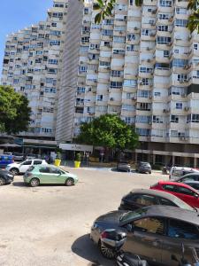 a parking lot with cars parked in front of a large building at SERVILUX 4 in Torremolinos