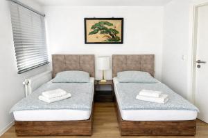 two twin beds in a room with a window at Ado Pension in Wedel
