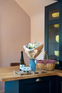 a table with a bowl of flowers and a bottle of beer at Orchard Barn in Teversall +27 photos