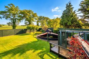 a backyard with a fence and a garden at Finest Retreats - The Grove Annexe in Craven Arms