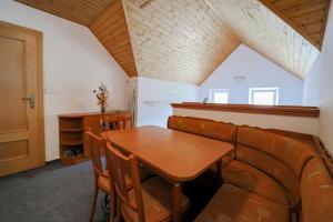 a dining room with a wooden table and chairs at Apartman Nina in Kvačany