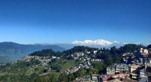 a town on a hill with mountains in the background at Hotel Queen in Darjeeling