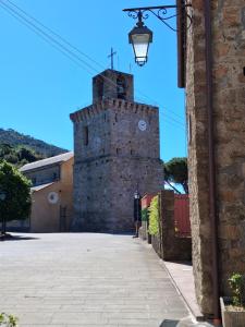 a tall brick tower with a clock on it at Natura e relax in Anzo