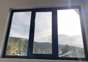 a window with a view of a mountain at A frame house with a view of mountains in Karakol