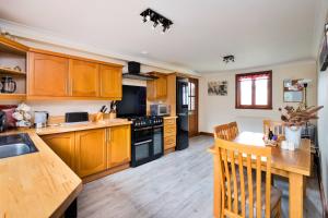 a kitchen with wooden cabinets and a wooden table at Finest Retreats - The Grove Annexe in Craven Arms