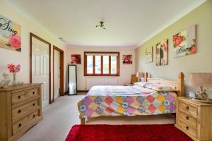 a bedroom with a bed and a red rug at Finest Retreats - The Grove Annexe in Craven Arms