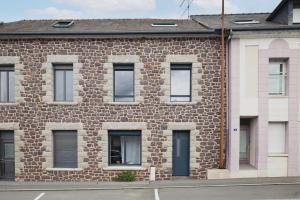 a brick building with many windows on a street at Marguerite in Bédée +11 photos