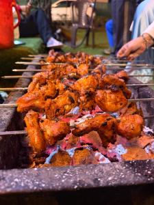 a grill with chicken and other food on it at Zabaish Riverside Cottage in Pahalgām