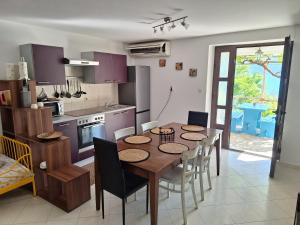 a kitchen and dining room with a table and chairs at Apartman Krivičić in Cres