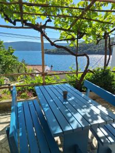 a blue picnic table with a view of the water at Apartman Krivičić in Cres