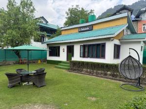 a yard with two tennis rackets in front of a house at Zabaish Riverside Cottage in Pahalgām